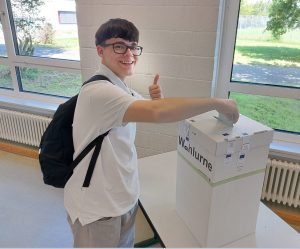 Das Bild zeigt einen Schüler bei der Stimmabgabe.